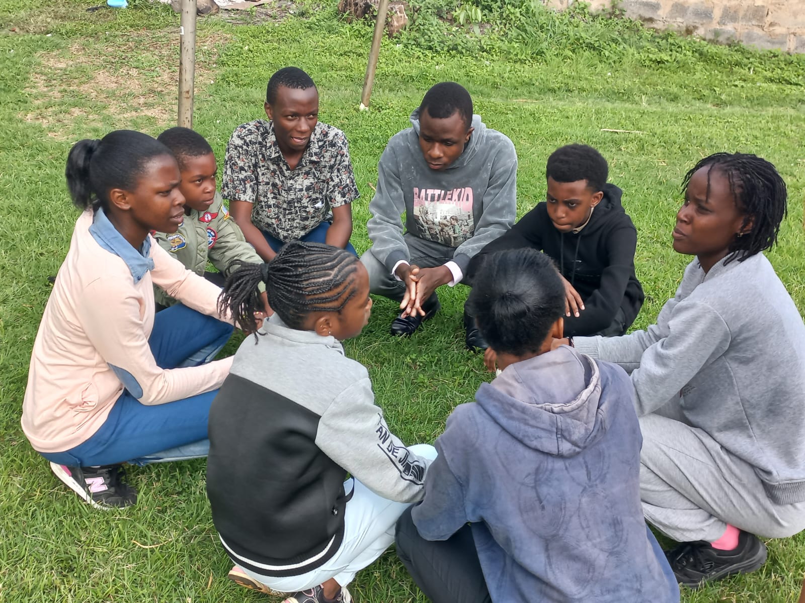 AKAD mentees in a small discussion circle on the grass